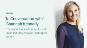 Webinar titled 'In Conversation with Shannah Kennedy: The importance of caring for self in an industry all about caring for others.' The image shows Shannah Kennedy, a woman with blonde hair, smiling and standing against a light background, wearing a dark blue blouse.